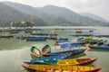 A yellow blue red green wooden boats on a lake against the backdrop of mountains Royalty Free Stock Photo