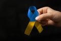 yellow blue ribbon in woman hands