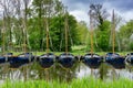 Yellow and blue sailboats anchored in a row in a canal in southern Holland