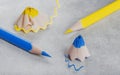 yellow and blue sharp pencil and blue and yellow pencil shavings. Royalty Free Stock Photo