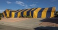 Yellow and blue striped termite tent covering a ranch style house Royalty Free Stock Photo