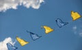 Yellow and blue triangular festival flags on sky background with white clouds. Outdoor Celebration Party Royalty Free Stock Photo