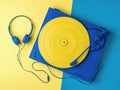 Yellow and blue vinyl record player and headphones on a two-tone background Royalty Free Stock Photo