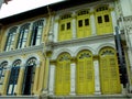 Yellow, blue and white windows on the facade of a colonial style building in Singapore Royalty Free Stock Photo