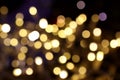 Yellow blurred bokeh lights of holiday decoration illumination in city. Abstract background with Christmas tree garland Royalty Free Stock Photo