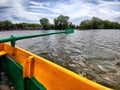 Yellow board of a wooden boat and green paddle on the water of lake, river, reservoir. Beautiful natural landscape. The Royalty Free Stock Photo