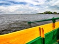 Yellow board of a wooden boat and green paddle on the water of lake, river, reservoir. Beautiful natural landscape. The Royalty Free Stock Photo