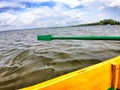 Yellow board of a wooden boat and green paddle on the water of lake, river, reservoir. Beautiful natural landscape. The Royalty Free Stock Photo