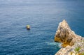 Yellow boat on blue dark water of Grotta di Lord Byron near coast with rock cliff, Portovenere town