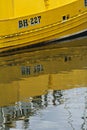 Yellow boat reflection in water in Eyemouth, Scotland, UK. 07.08.2015
