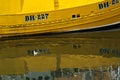 Yellow boat reflection in water in Eyemouth, Scotland, UK. 07.08.2015