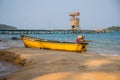 Yellow boat on white sand beach. Tropical island simple lifestyle. Rustic fishing boat.