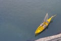 Yellow boat with wine barrels view from above. Boat on water top aerial view. Yellow wooden boat in Porto, Portugal.