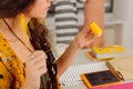 Calm dressmaker holding yellow bobbing and taking a thread