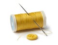 Yellow bobbin, needle and sewing button Royalty Free Stock Photo