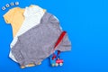 Yellow bodysuit, gray bodysuit and green cotton bodysuit with children`s toy and blocks. Clothes for newborns on a blue backgroun Royalty Free Stock Photo