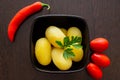 Boiled potatoes with chili peppers and tomatoes on a dark background Royalty Free Stock Photo