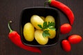 Boiled potatoes with chili peppers and tomatoes on a dark background Royalty Free Stock Photo