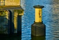 Yellow bollard with black foot in the water of the harbour basin