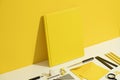 Yellow book cover mockup and stationary flat lay on yellow background Royalty Free Stock Photo