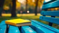 A yellow book sitting on top of a blue bench Royalty Free Stock Photo