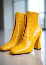 yellow boots made of lacquered eco-leather imitating the skin of a crocodile