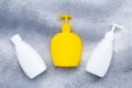 Yellow bottle with detergent, liquid soap. White flacon. Set of plastic bottles with dispenser on a gray background. Pump lotion.