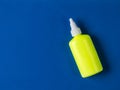 Yellow bottle with a white cap on a blue background. Royalty Free Stock Photo