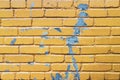 Yellow brick wall with blue paint texture background. Old weathered and cracked bricks Royalty Free Stock Photo