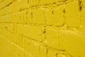 A yellow brick wall painted with paint extending into the distance Royalty Free Stock Photo