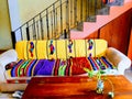 Yellow brick wall pink stairway colorful couch with Mexican Turtle blanket and floor table