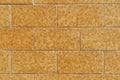 Yellow brick wall of symmetrical stone blocks with orange and brown spots Royalty Free Stock Photo