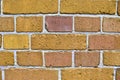 Yellow brick walls with old and weathered stones and cracks in high resolution