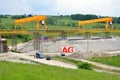 Yellow bridge crane on construction site of slovak D1 highway. Except for the crane there are some workers and cars.