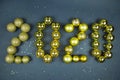 Yellow bright balls with sequins folded in the inscription 2020 on a blue-green background. Christmas, toys, New year Royalty Free Stock Photo