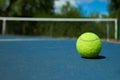 Yellow tennis ball on blue carpet of opened court. Royalty Free Stock Photo