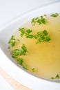 Yellow broth with herbs Royalty Free Stock Photo