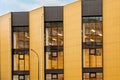 Yellow-brown modern ventilated facade with large windows. Fragment of new commercial complex. Part of urban property Royalty Free Stock Photo