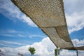 Yellow brown sunshade against cloudy blue sky