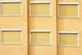 Yellow Building Facade with Six Closed Windows Shutters Royalty Free Stock Photo