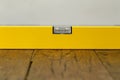 Yellow building level lies on a wooden table Royalty Free Stock Photo