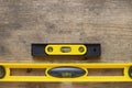 Yellow building level on the old wood table, engineering work tool concept Royalty Free Stock Photo