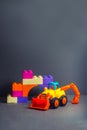 Yellow buldozer and different coloured bricks. Shovel car. Building transport. Toys for little children Royalty Free Stock Photo