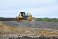 Yellow buldozer or excavator performs earthwork ground level layout