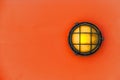 Yellow bulkhead light ship deck lamp on installed on orange color wooden wall background. Royalty Free Stock Photo