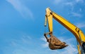 Bulldozer arm of a backhoe bucket on blue sky