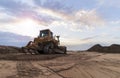 The yellow bulldozer stands on the ground. Against the background of the sunset sky Royalty Free Stock Photo