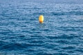 Yellow buoy on background of blue sea, concept loneliness