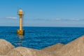 Yellow buoy light off ocean coast Royalty Free Stock Photo