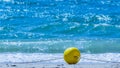 Yellow buoy on a sandy beach on a rope